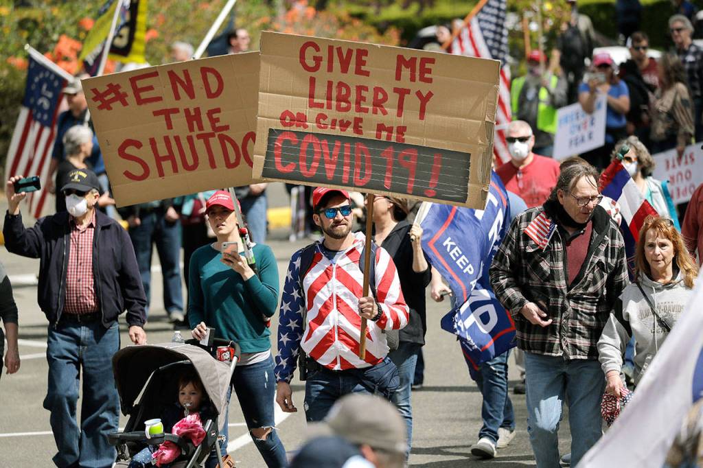 Demonstrators begin to gather Sunday at a protest in Olympia opposing Washington states stay-home order to slow the coronavirus outbreak. Gov. Jay Inslee has blasted President Donald Trumps calls to liberate parts of the country from stay-at-home and other orders that are designed to combat the spread of the coronavirus. Inslee says that Trump is fomenting a potentially deadly insubordination among his followers before the pandemic is contained. (AP Photo/Elaine Thompson)