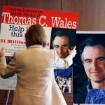Seattle Mayor Jenny Durkan moves a poster into place alongside a photo of slain Assistant United States Attorney Thomas Wales after a news conference giving an update on the unsolved 2001 slaying of Wales, on Feb. 21, 2018, in Seattle. (AP Photo/Elaine Thompson, file)