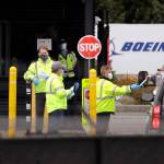 A worker is handed a protective mask while entering a Boeing production plant Tuesday in Everett. (AP Photo/Elaine Thompson)