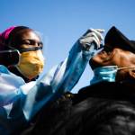 Dr. Ala Stanford administers a COVID-19 swab test on Wade Jeffries in the parking lot of Pinn Memorial Baptist Church in Philadelphia, April 22. Stanford and other doctors formed the Black Doctors COVID-19 Consortium to offer testing and help address heath disparities in the African American community. (Matt Rourke / Associated Press)