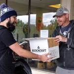 Ben Branan (left) receives his online order from Doug Hall at The Republic Bottleshop on April 30 in Marysville. (Kevin Clark / The Herald)