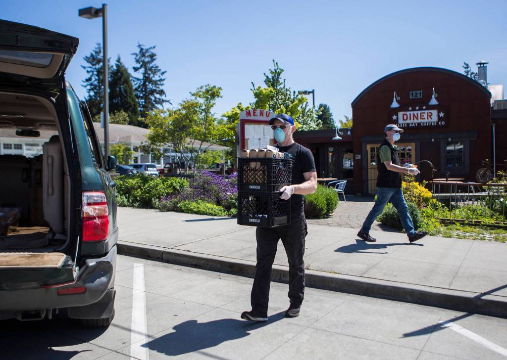 Des Rock, owner of Useless Bay Coffee Company, loads his car with soup for Whidbey Island Nourishes and coffee beans for the Star Store in Langley. (Olivia Vanni / The Herald)