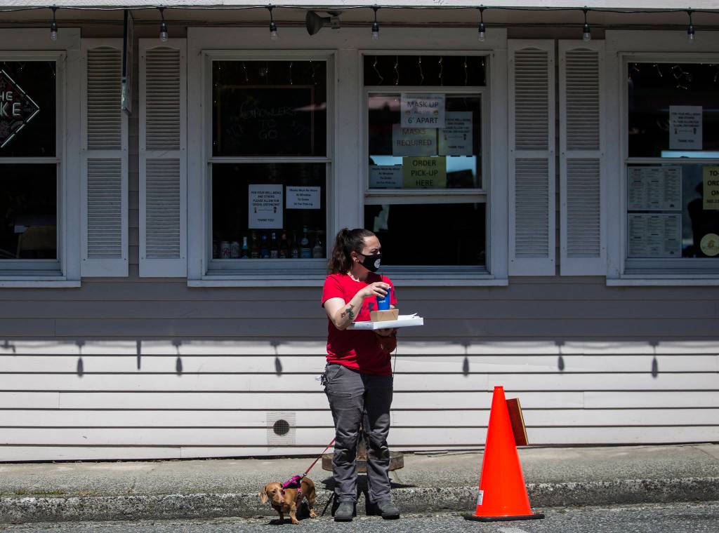 Celean Larmoe and her dog, Sarah, wait to cross First Street in Langley. (Olivia Vanni / The Herald)