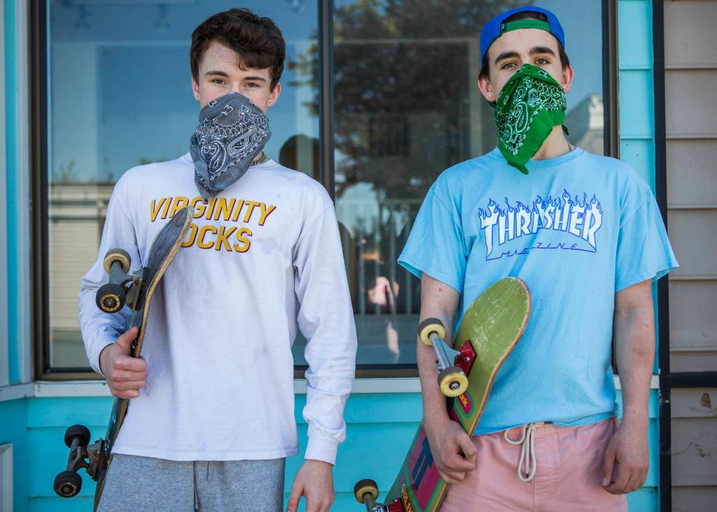 Caleb McArthy, 17 (left), and Hank McCarroll, 15 (right), wear bandana masks while skateboarding in Langley. (Olivia Vanni / The Herald)