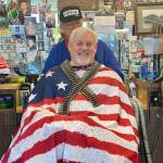 Mike Daniels gets a haircut Tuesday from Bob Martin at Stag Barber and Styling in Snohomish. Dozens of people have lined up since the shop reopened on Saturday. (Andrea Brown / The Herald)