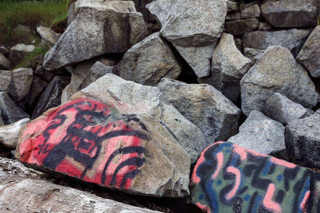 Graffiti dots the boulders and concrete barriers along the shore at Howarth Park in Everett. (Kevin Clark / The Herald)