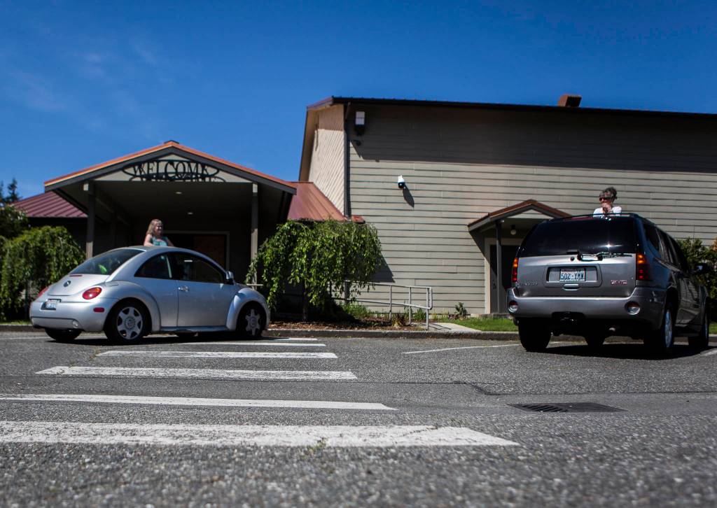 People chat from their cars before the start of the drive-in service at Marysville Foursquare Gospel Church on Sunday. (Olivia Vanni / The Herald)