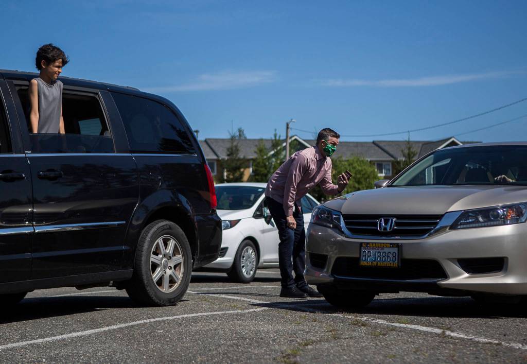 Pastor Aaron Thompson checks in to make sure everyone has been able to connect to the lifestream from the parking lot before his service at Marysville Foursquare Gospel Church on Sunday, May 10, 2020 in Marysville, Wa. (Olivia Vanni / The Herald)
