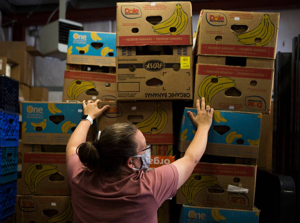 Becky Grannan helps move a pallet of empty banana boxes at the Sky Valley Food Bank on Friday, May 15, 2020 in Monroe, Wa. (Olivia Vanni / The Herald)