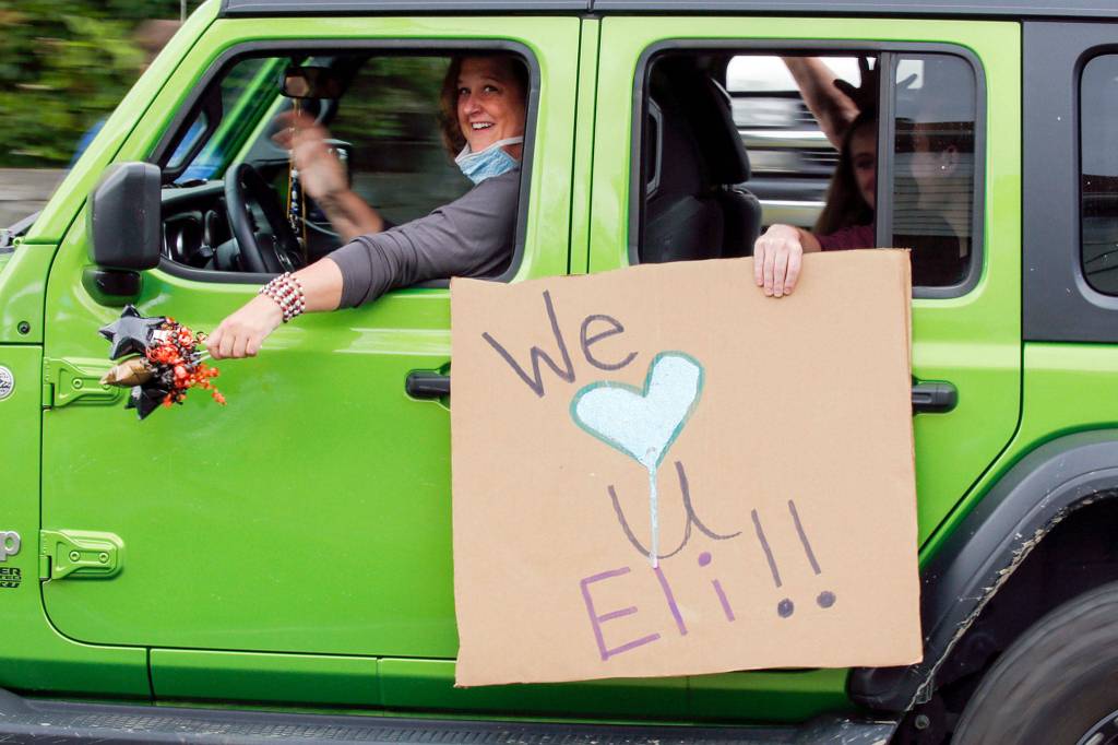 Friends and family close out Eli Kincaids Make-A-Wish parade of first responders driving to his home Tuesday afternoon in Lynnwood. (Kevin Clark / The Herald)