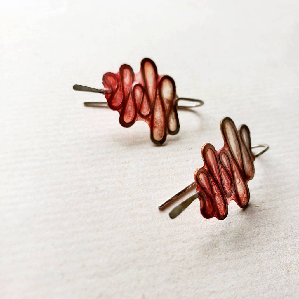 Brauner was inspired by a rivers bend to make these metal-and-paper earrings. (VERSO)