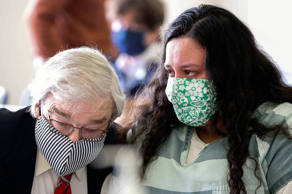 Walter Peale (left) talks with his client Lendsay Meza on Thursday afternoon at the Snohomish County Courthouse in Everett. (Kevin Clark / The Herald)
