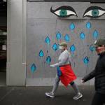 Pedestrians wearing face masks walk past art by Patricia Rovzar on her boarded-up art gallery, May 16, in downtown Seattle. On Saturday, officials reported that Washington state had reached the grim milestone of 1,000 deaths from the coronavirus. (Ted S. Warren / Associated Press)
