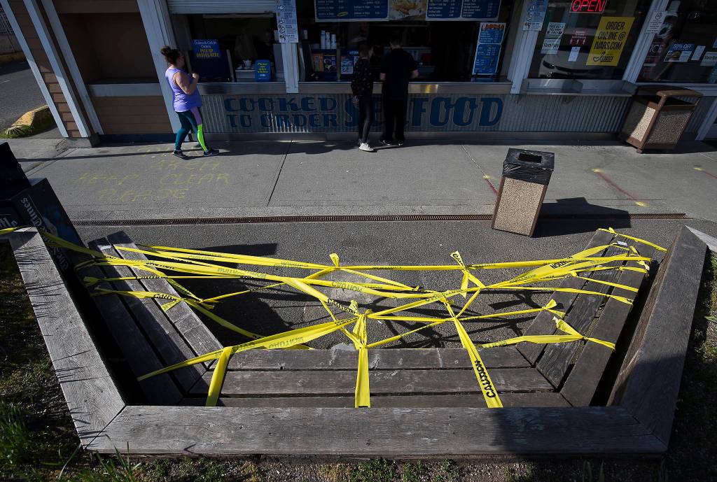 Customers maintain social distancing while ordering food at Ivars Seafood at Lighthouse Park in Mukilteo. (Andy Bronson / The Herald)