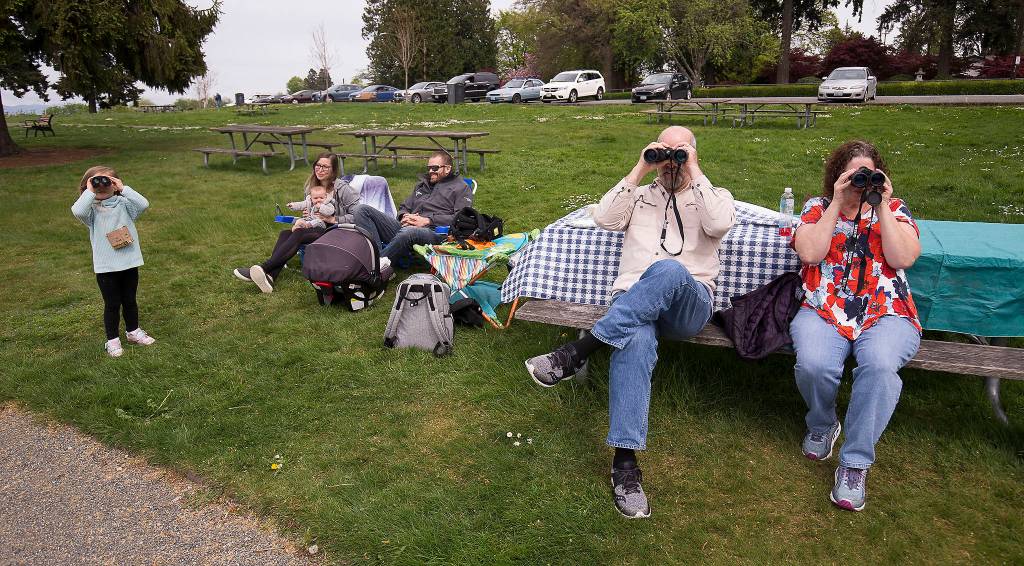 Grant and Linda Lander look for whales and birds with as their granddaughter, Kinsley Kurisu, at Legion Park in Everett. (Andy Bronson / The Herald)