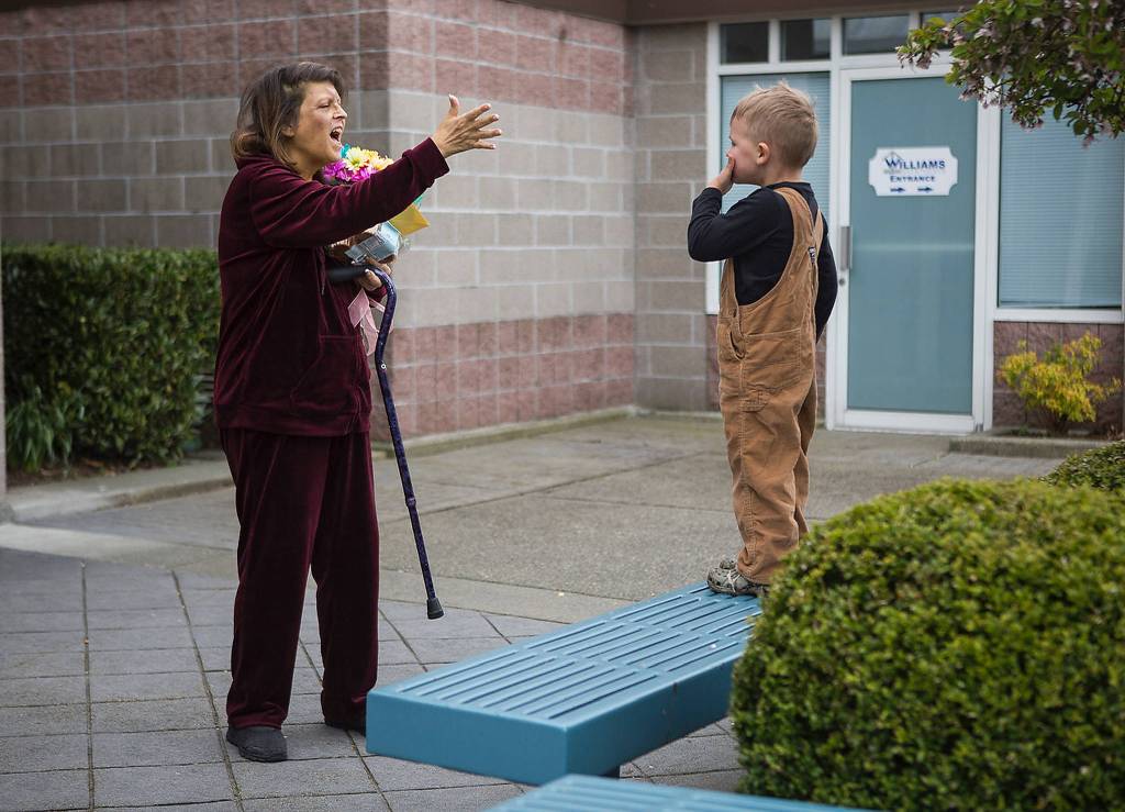 Memphis McDermott, 3, blows kisses to his grandmother, Linda Jackson, in Everett after he drops off flowers and cupcakes for her for Easter. (Olivia Vanni / The Herald)