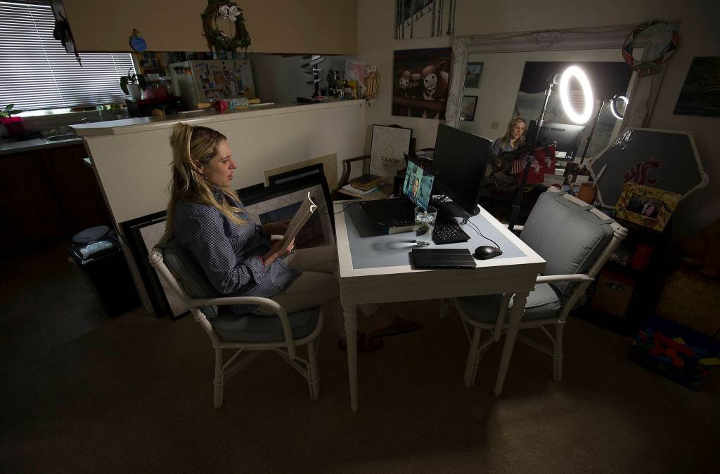Recording a teaching session, Jackson High School para-educator Brigitte Ashley reads a book to her students while at home in Mill Creek. (Andy Bronson / The Herald)