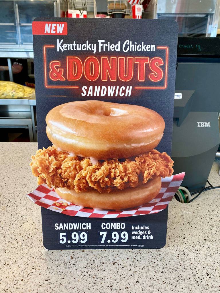 A sign advertises the Kentucky Fried Chicken & Donuts sandwich during a test market promo in Everett. (Andrea Brown / The Herald)