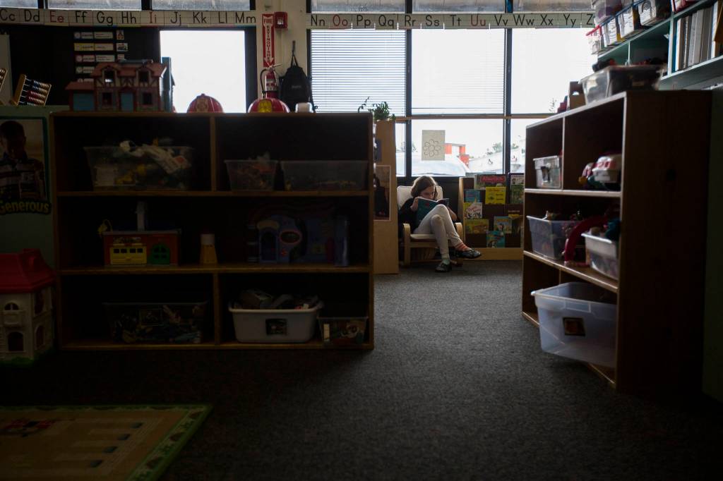 Indiana Smasne reads in an empty corner of a classroom. (Olivia Vanni / The Herald)