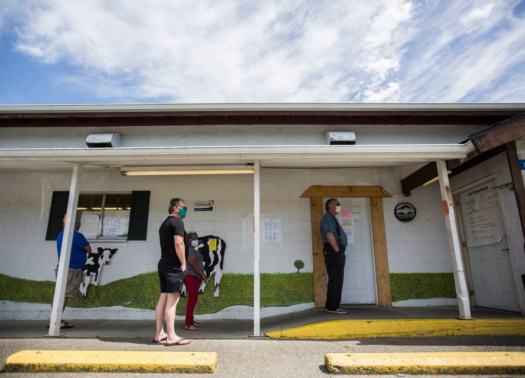 Customers form a line outside of Silvana Meats, which is limiting two customers inside at a time, on Friday, May 29, 2020 in Silvana, Wa. (Olivia Vanni / The Herald)