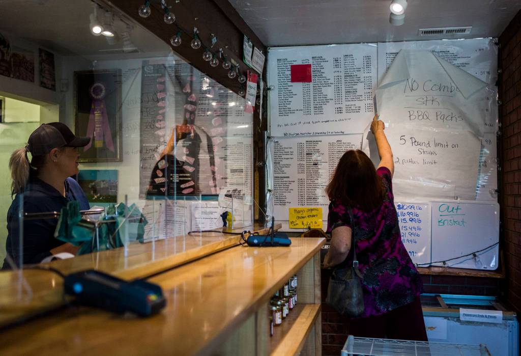 A customer reads through Silvana Meats extensive list of meats and cuts on Friday, May 29, 2020 in Silvana, Wa. (Olivia Vanni / The Herald)