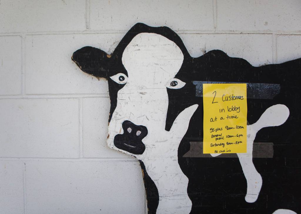 A sign alerting customers to a 2 customer in lobby limit is taped to a cow cutout outside of Silvana Meats on Friday, May 29, 2020 in Silvana, Wa. (Olivia Vanni / The Herald)
