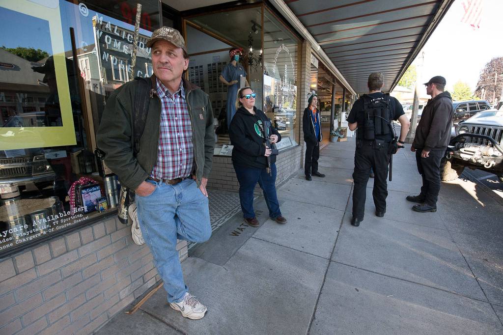 Armed citizens stand along First Street to protect businesses from possible looters on Monday in Snohomish. (Andy Bronson / The Herald)