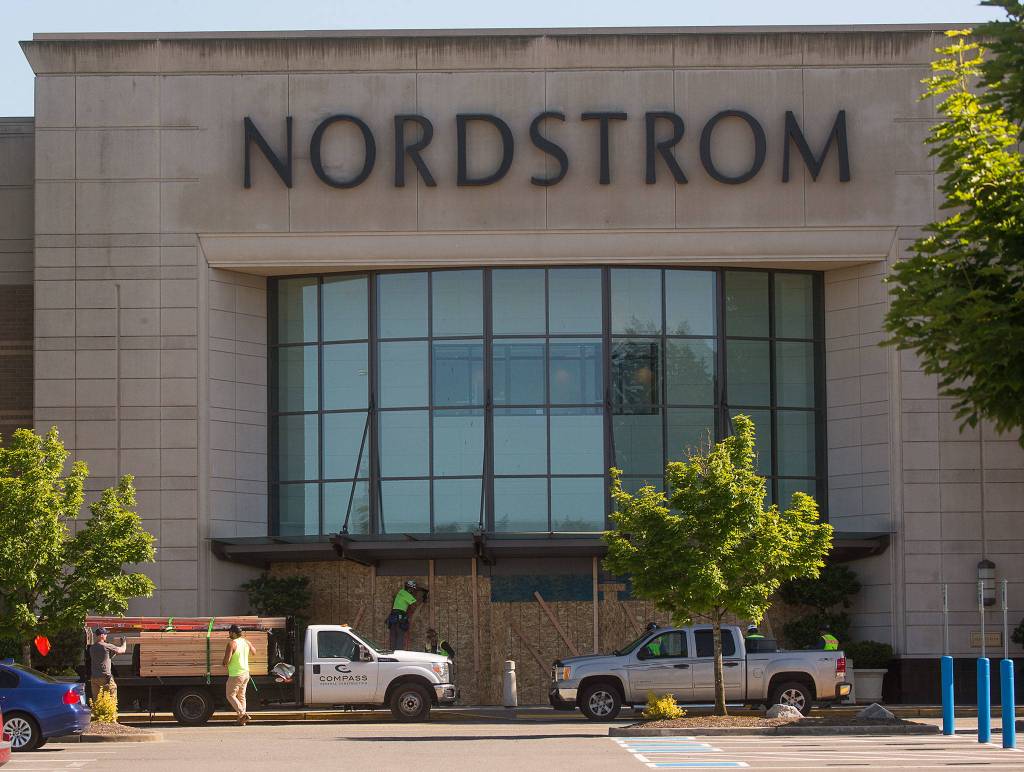 Workers board up Nordstrom from possible looting at the Alderwood mall on Monday in Lynnwood. (Andy Bronson / The Herald)