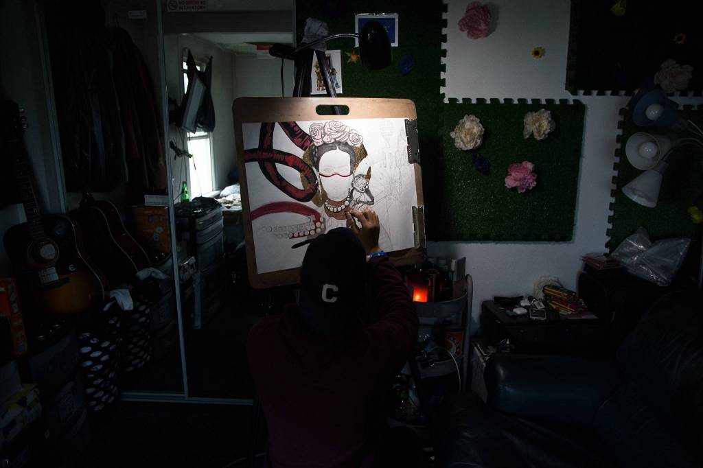 Artist Julius Wilson works on a Freda Kahlo-inspired drawing in his latest series, Not All Heroes Wear Capes. (Andy Bronson / The Herald)