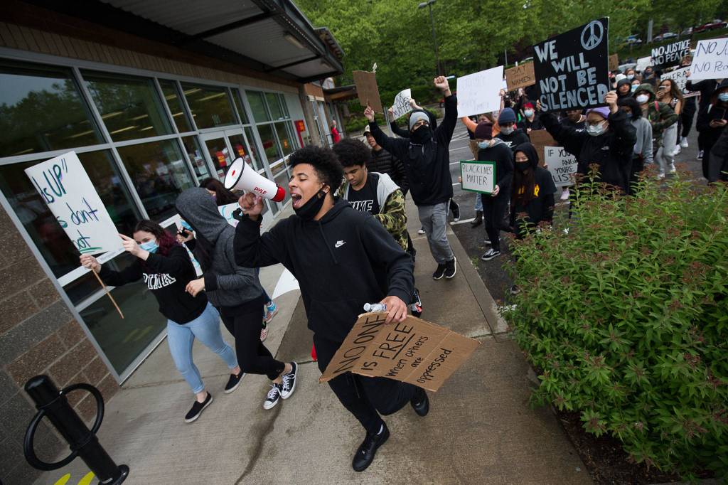 A young man uses a bullhorn as he leads about two hundred protesters though Mill Creek, to protest the killing of George Floyd, on Tuesday, June 2, 2020 in Mill Creek, Wa. (Andy Bronson / The Herald)