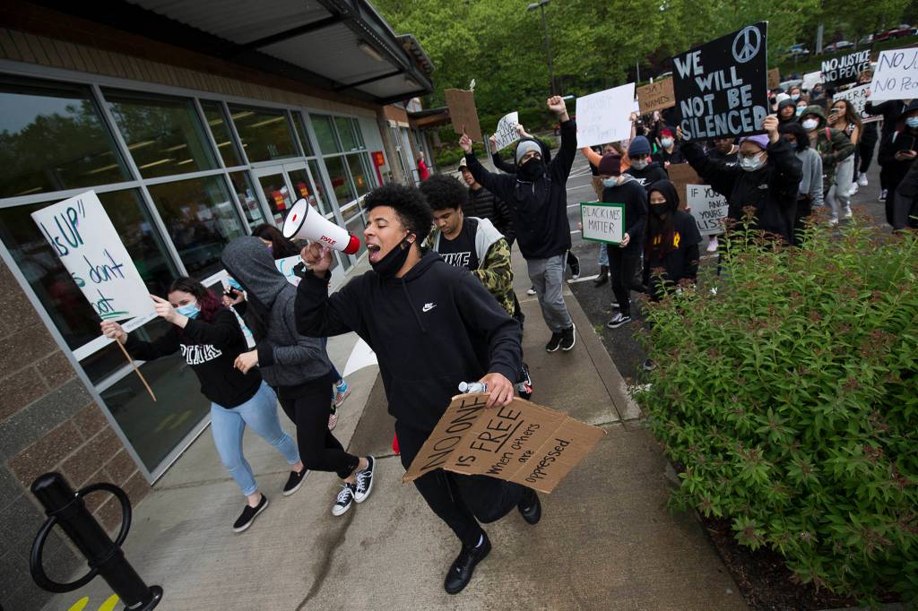 A young man uses a bullhorn as he leads about two hundred protesters though Mill Creek, to protest the killing of George Floyd, on Tuesday, June 2, 2020 in Mill Creek, Wa. (Andy Bronson / The Herald)