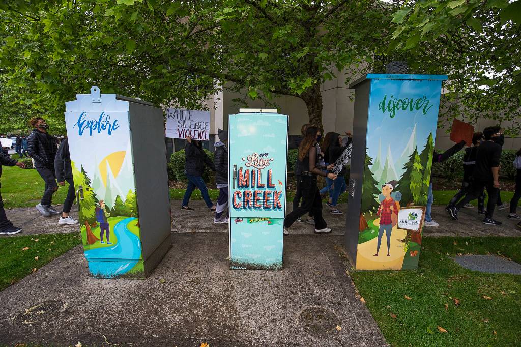 Protesters march past painted electrical boxes as they protest the killing of George Floyd on Tuesday, June 2, 2020 in Mill Creek, Wa. (Andy Bronson / The Herald)