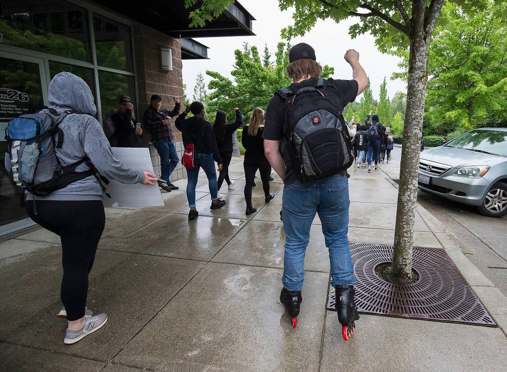 A protester inline skates with about bout two hundred other protesters as they march though Mill Creek City Center, to protest the killing of George Floyd, on Tuesday, June 2, 2020 in Mill Creek, Wa. (Andy Bronson / The Herald)
