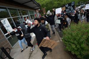 A young man uses a bullhorn as he leads about two hundred protesters though Mill Creek, to protest the killing of George Floyd, on Tuesday, June 2, 2020 in Mill Creek, Wa. (Andy Bronson / The Herald)
