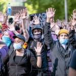 Protesters chant hands up, dont shoot as they march Monday in Seattle. (Dean Rutz/The Seattle Times via AP)