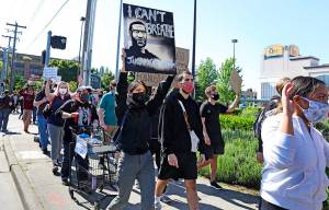 People peacefully protest at University Village on Monday in Seattle as demonstrations continued, sparked by the death of George Floyd in Minneapolis. (Ken Lambert/The Seattle Times via AP)