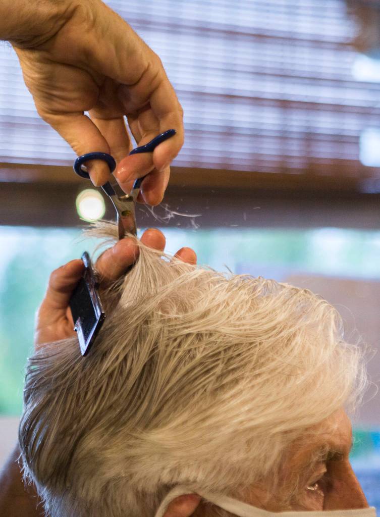 Steve Iblings begins trimming Bob DeFrangs hair Saturday in Lake Stevens. (Olivia Vanni / The Herald)