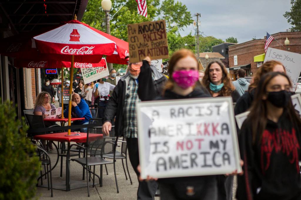 Protesters walk by Cathouse Pizza on First Street on Friday in Snohomish. (Olivia Vanni / The Herald)