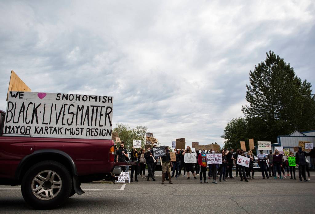 Protesters gather along First Street on Friday in Snohomish. (Olivia Vanni / The Herald)