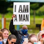A man raises a sign during the Justice March for George Floyd in Monroe on Thursday morning. (Kevin Clark / The Herald)