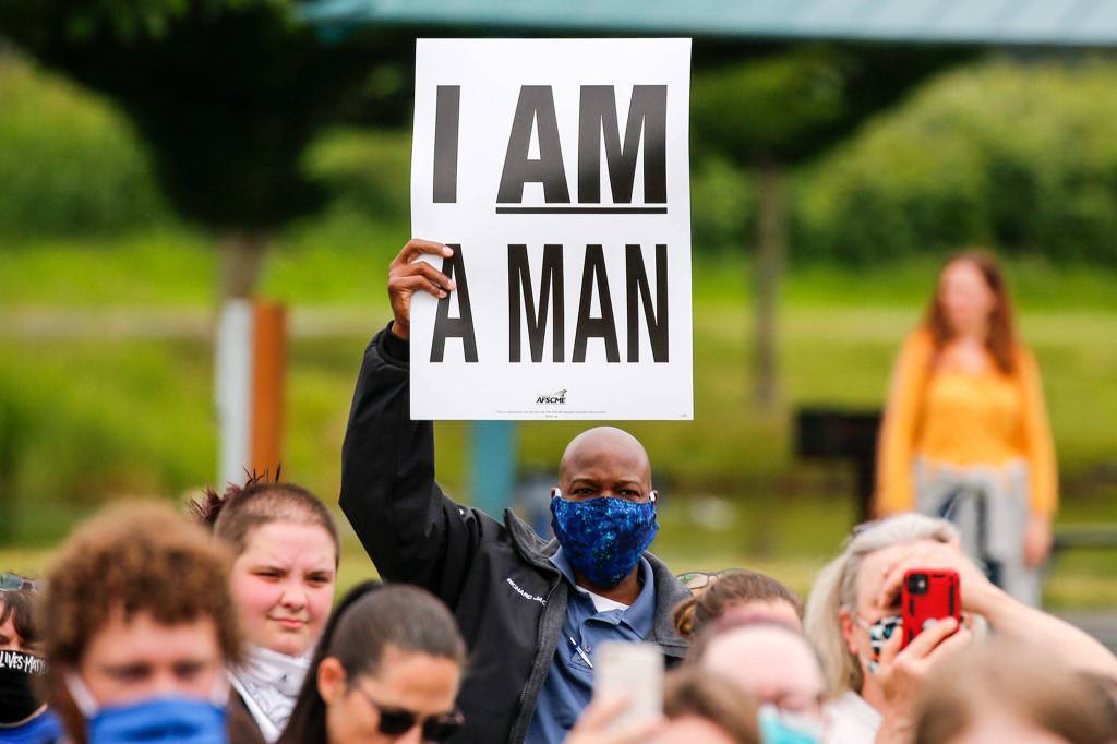 A man raises a sign during the Justice March for George Floyd in Monroe on Thursday morning. (Kevin Clark / The Herald)