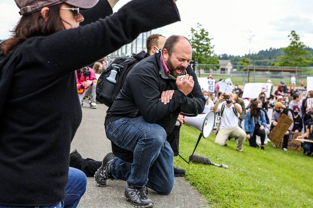 Geoffrey Thomas, mayor of Monroe, leads protesters in taking a knee and prayer during the Justice March for George Floyd in Monroe on Thursday morning. (Kevin Clark / The Herald)