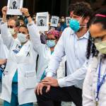 Health care workers take a knee for 10 minutes as part of White Coats 4 Black Lives at Providence Regional Medical Center Everett on Friday morning. (Kevin Clark / The Herald)