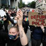 Demonstrators march toward Seattle City Hall on Wednesday in Seattle, following protests over the death of George Floyd, a black man who died in police custody in Minneapolis. (AP Photo/Elaine Thompson)