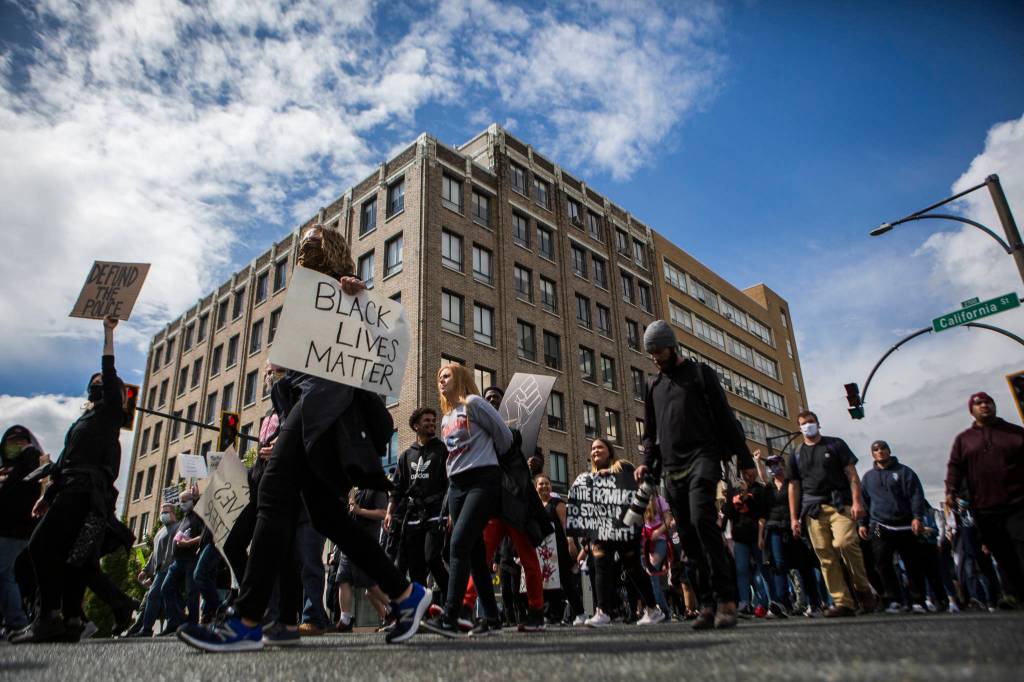 Protesters walk down Colby Avenue while chanting on Saturday in Everett. (Olivia Vanni / The Herald)