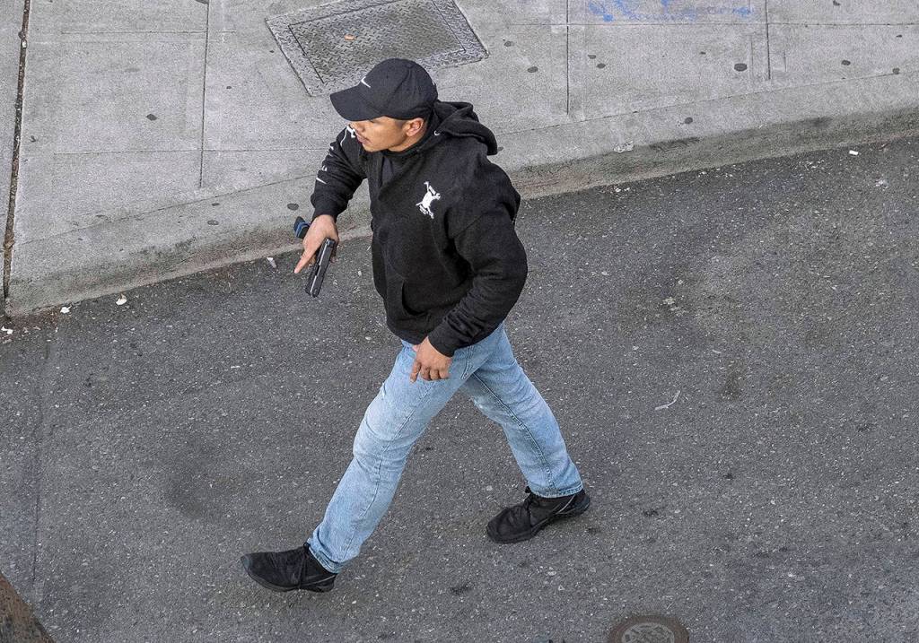 A man holds what appears to be a firearm after having driven at George Floyd protesters Sunday in Seattle. (Dean Rutz/The Seattle Times via AP)