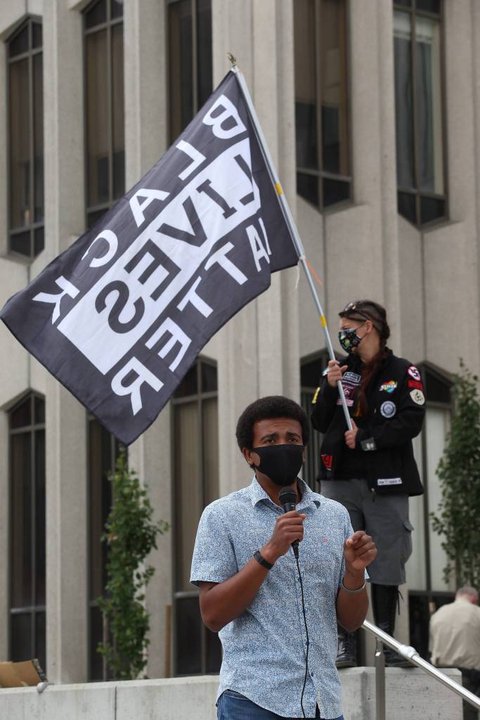 Michael Larson speaks outside the Snohomish County Courthouse on Monday after marching through downtown Everett. (Andy Bronson / The Herald)