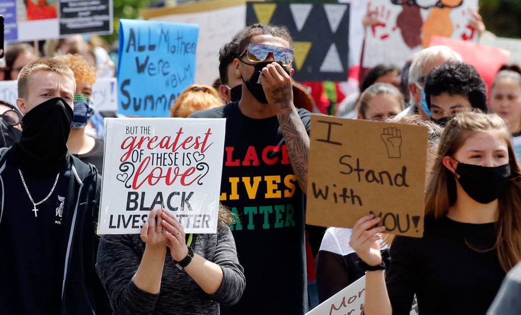 Young people hold signs and chant as they march through the core of Marysville Thursday afternoon. (Kevin Clark / The Herald)