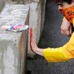 A man leaves a red paint handprint on a barricade near a closed Seattle police precinct Tuesday in Seattle, following protests over the death of George Floyd. (AP Photo/Elaine Thompson)