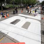 People work to dry off large letters that read Black Lives Matter painted on a street near Cal Anderson Park on Thursday, inside what is being called the Capitol Hill Autonomous Zone in Seattle. (AP Photo/Ted S. Warren)